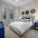 a bed in a spacious bedroom with large windows